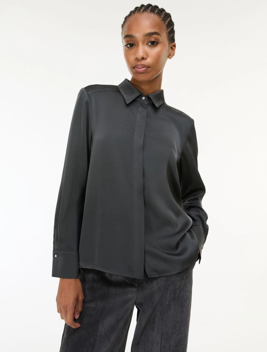 woman wearing grey satin shirt on a white background side view