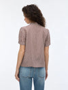 woman wearing geometric blouse with neck tie on white background rear view