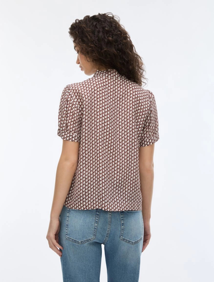 woman wearing geometric blouse with neck tie on white background rear view