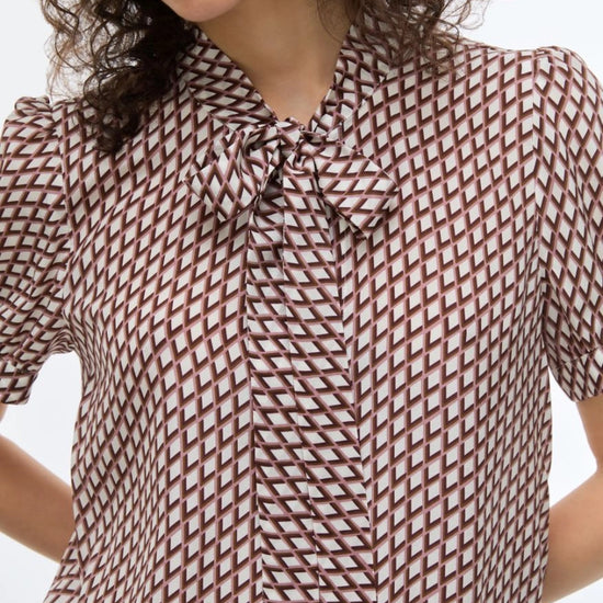 geometric blouse with neck tie on white background close up