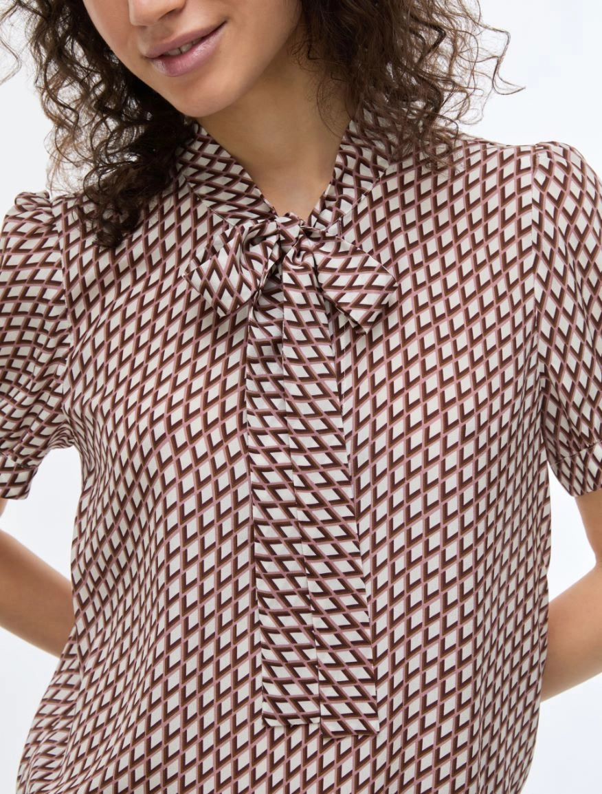 geometric blouse with neck tie on white background close up
