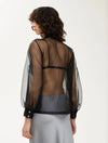 black sheer blouse with tie neck, long puffy sleeves and chest pockets rear view 