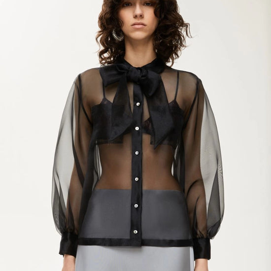 black sheer blouse with tie neck, long puffy sleeves and chest pockets model shot