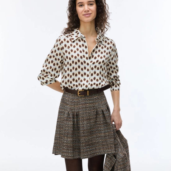 woman wearing blue and brown spotted shirt with check skirt 