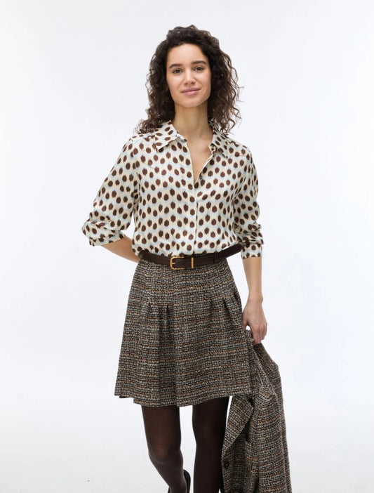 woman wearing blue and brown spotted shirt with check skirt 