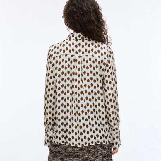 Person wearing a polka dot shirt with a white background