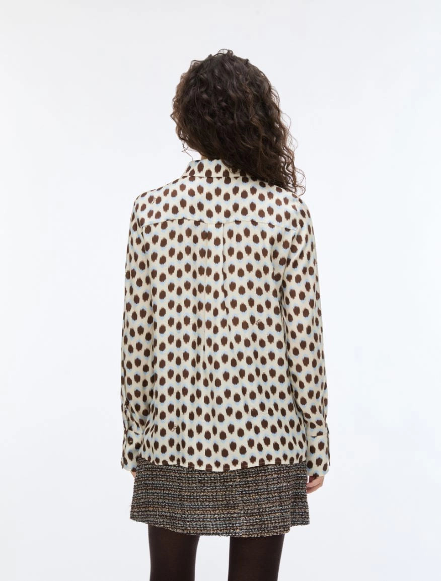 Person wearing a polka dot shirt with a white background