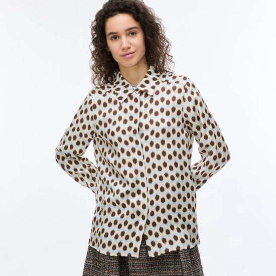 Woman wearing a polka dot blouse and skirt on a white background