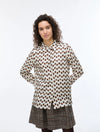 Woman wearing a polka dot blouse and skirt on a white background