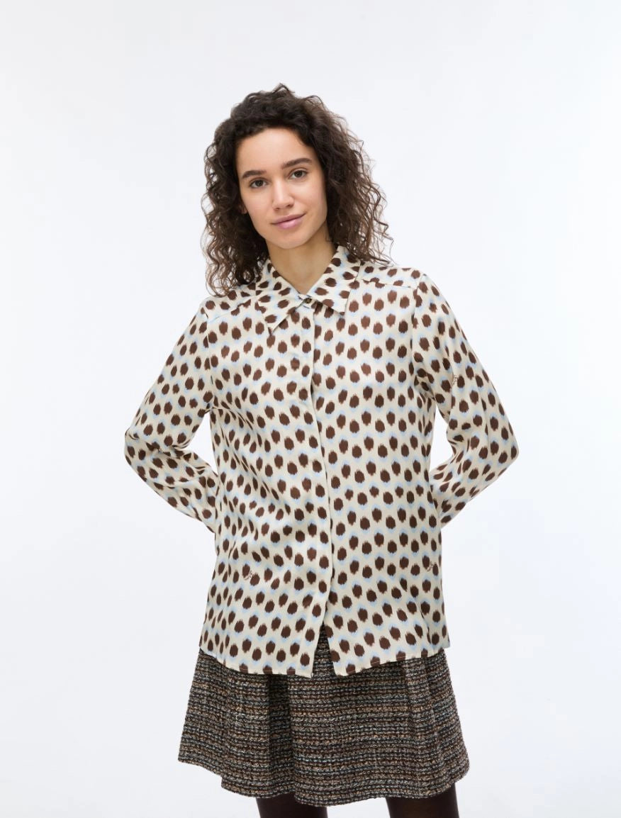 Woman wearing a polka dot blouse and skirt on a white background
