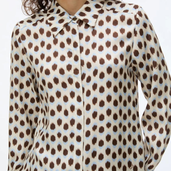 woman wearing blue and brown spotted shirt with check skirt close up