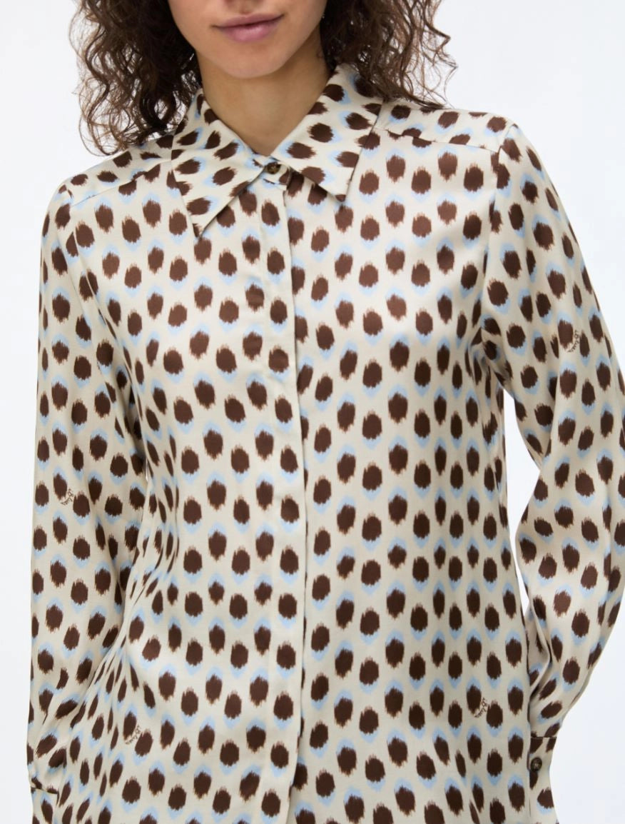 woman wearing blue and brown spotted shirt with check skirt close up