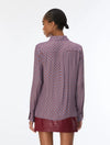 woman wearing a blue and red pattern shirt and red skirt on a white background rear view