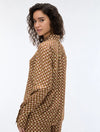 woman wearing a geometric brown and cream shirt on a white background rear view