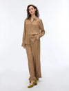 woman wearing a geometric brown and cream shirt with matching trousers on a white background