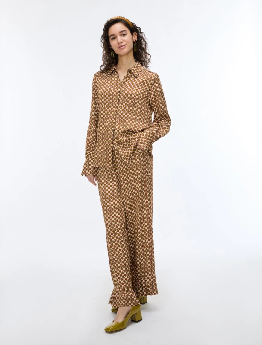 woman wearing a geometric brown and cream shirt with matching trousers on a white background