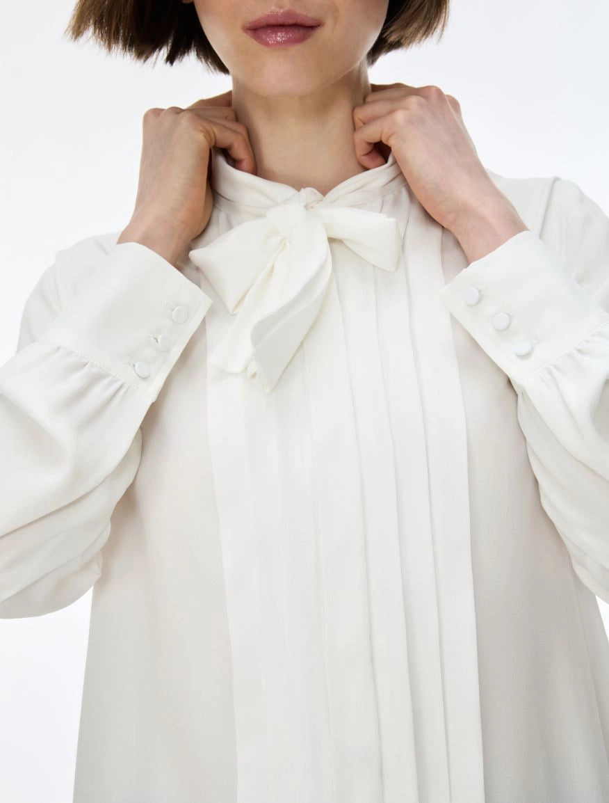 white blouse with neck tie on white background close up 