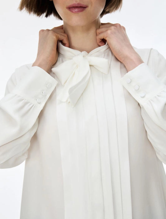 white blouse with neck tie on white background close up 