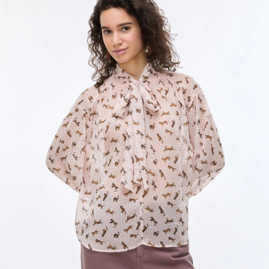 woman wearing pink blouse with tiger print with purple jeans