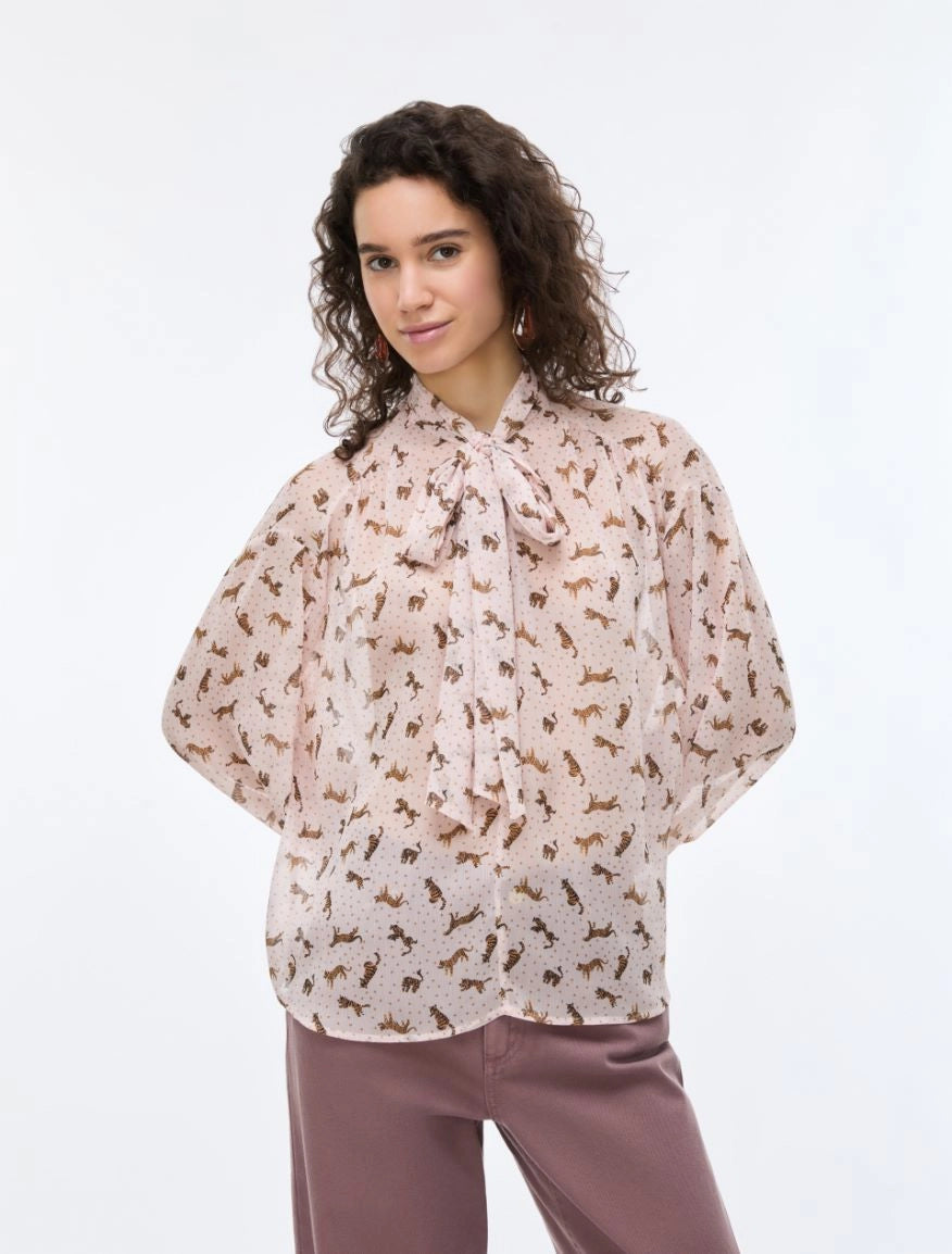 woman wearing pink blouse with tiger print with purple jeans
