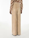 A model shown from the back wearing high-waisted, wide-leg taupe pants and a brown and beige plaid shirt, photographed against a clean white studio background.
