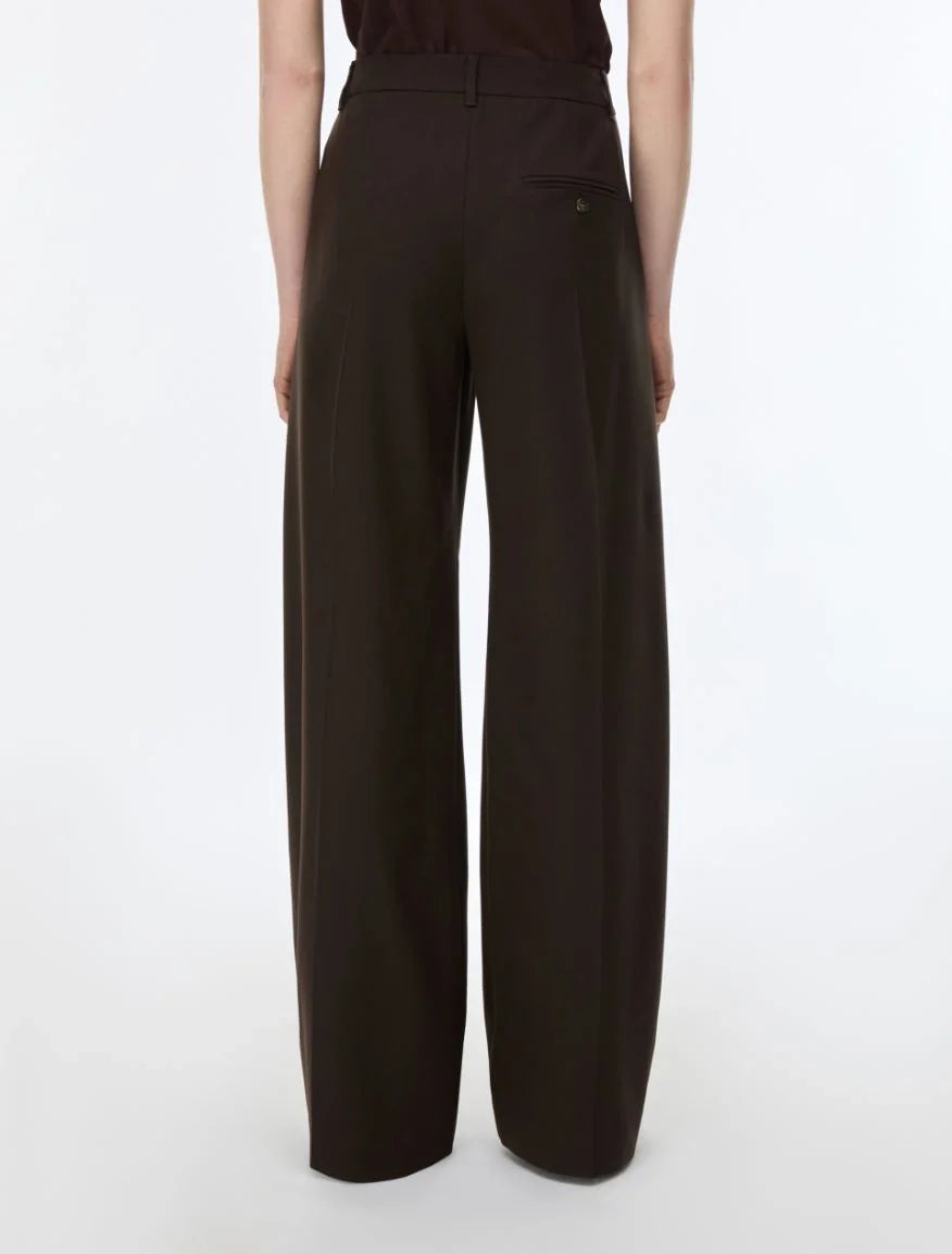 A model shown from the back wearing dark brown wide-leg trousers, photographed against a clean white studio background.