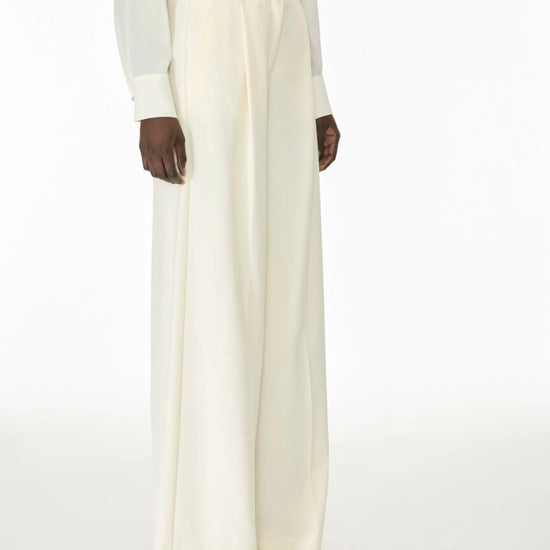 Woman wearing cream trousers side view
