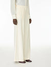 Woman wearing cream trousers side view