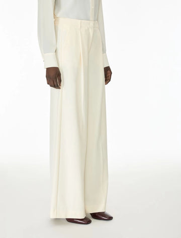 Woman wearing cream trousers side view