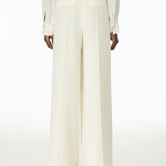 Woman wearing cream trousers rear view