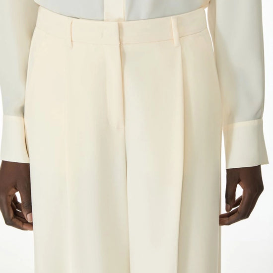 Woman wearing cream trousers close up