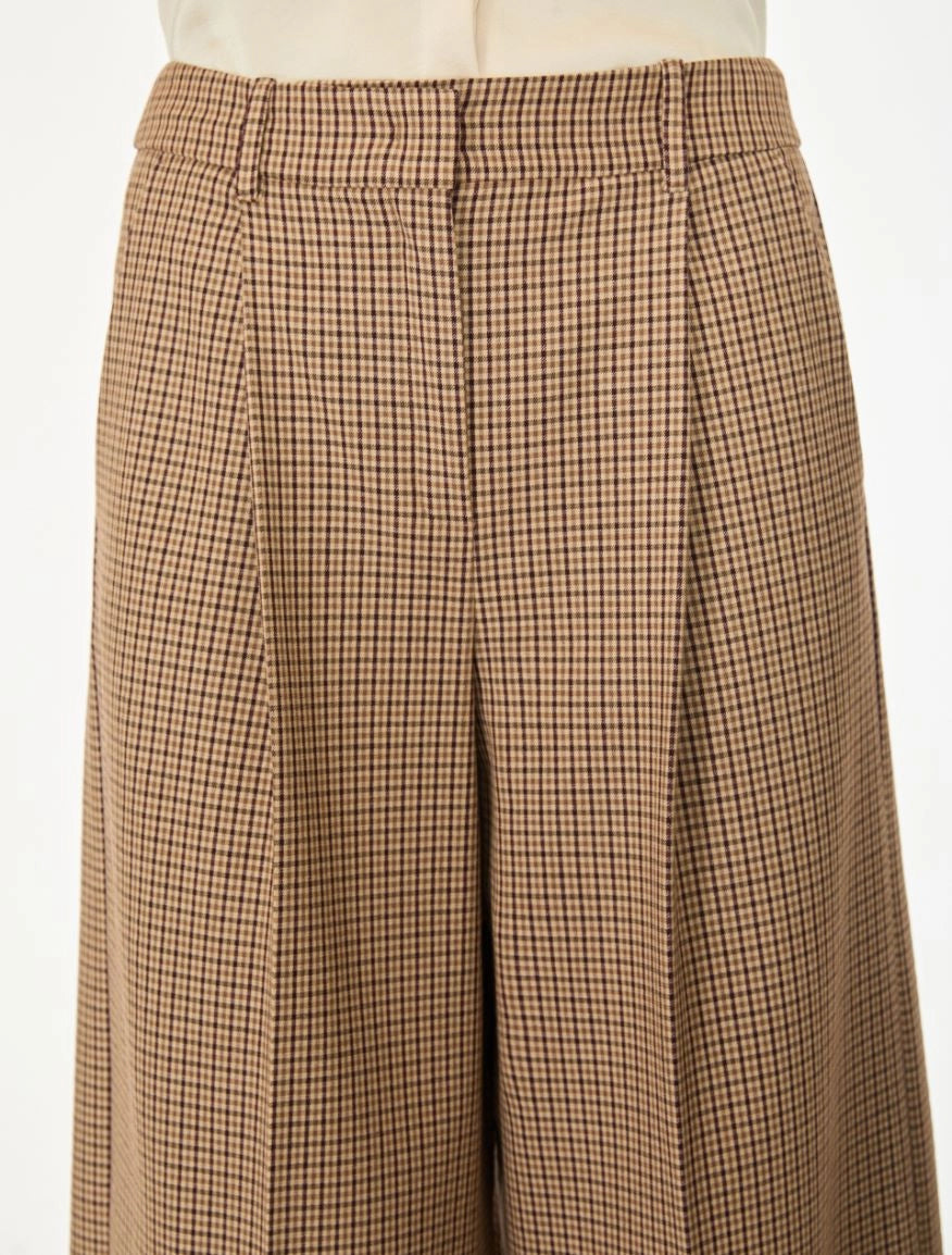 Brown check wide leg trousers on a white background close up