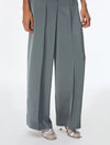 A person wearing high-waisted, wide-leg gray trousers with a smooth satin-like finish, paired with metallic silver heeled sandals against a plain white studio background.