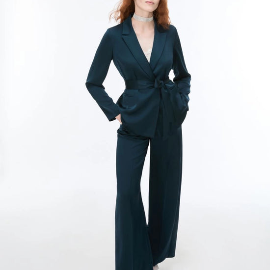 Woman wearing Blue satin trousers and matching blazer on a white background