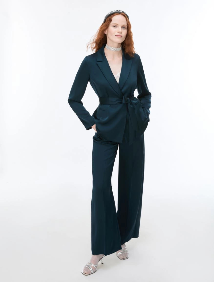 Woman wearing Blue satin trousers and matching blazer on a white background