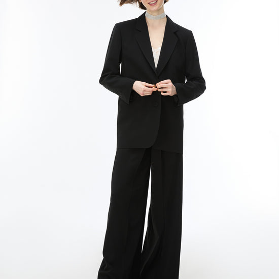 woman wearing black wide leg trousers with blazer