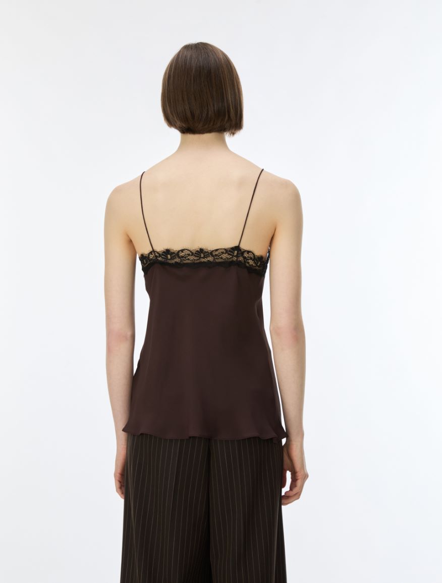 A model shown from the back wearing a dark brown camisole top with black lace trim at the neckline and matching dark pleated trousers, against a plain white studio background.