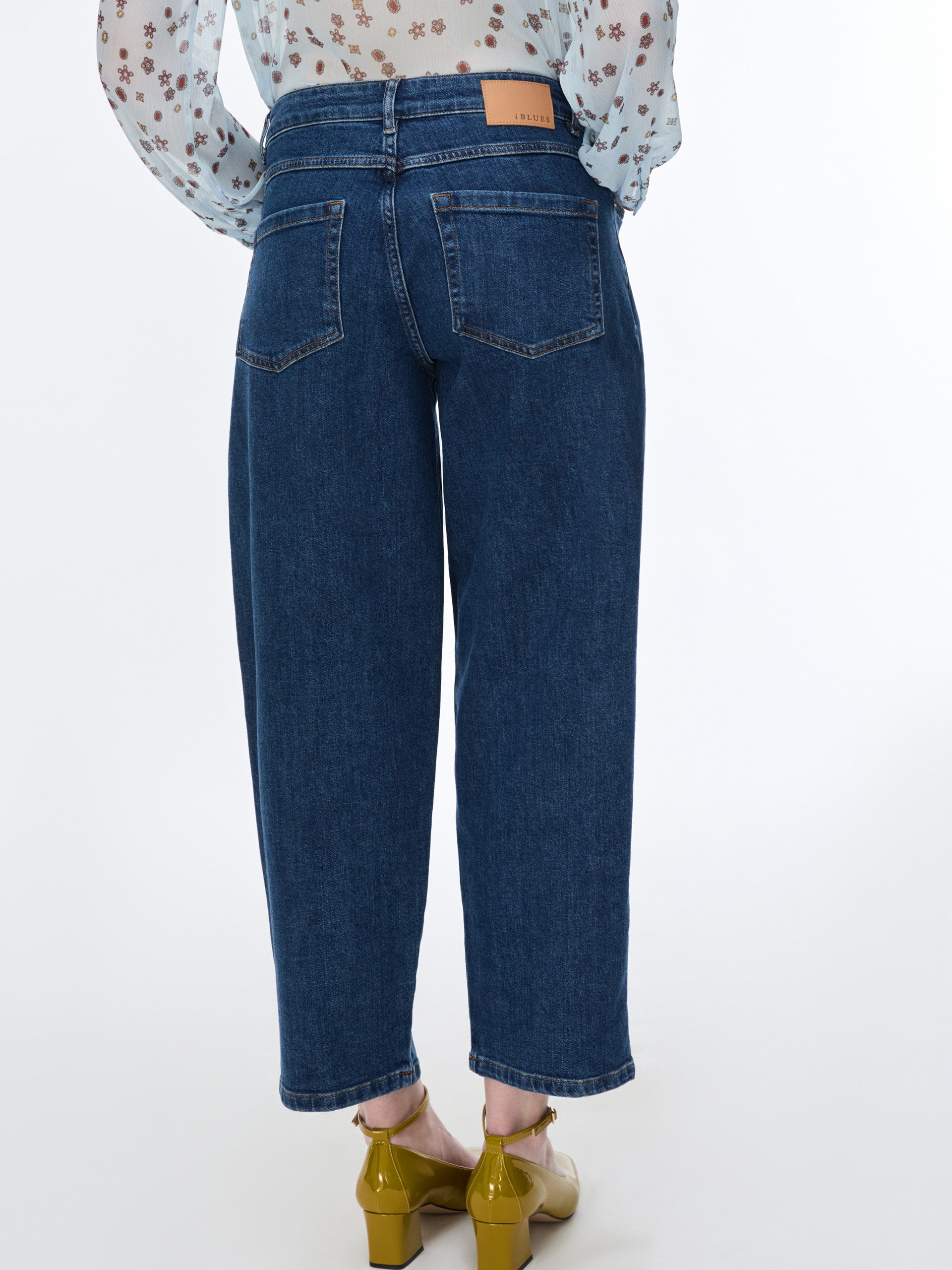Person wearing blue jeans on a white background