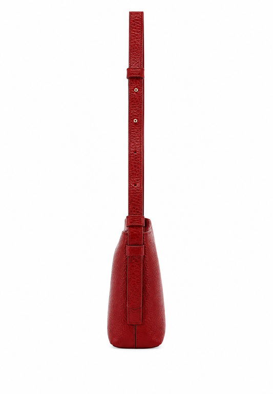 A red textured leather shoulder bag shown from the back, featuring a long matching strap and a vertical strap detail on the back panel, set against a plain white background.