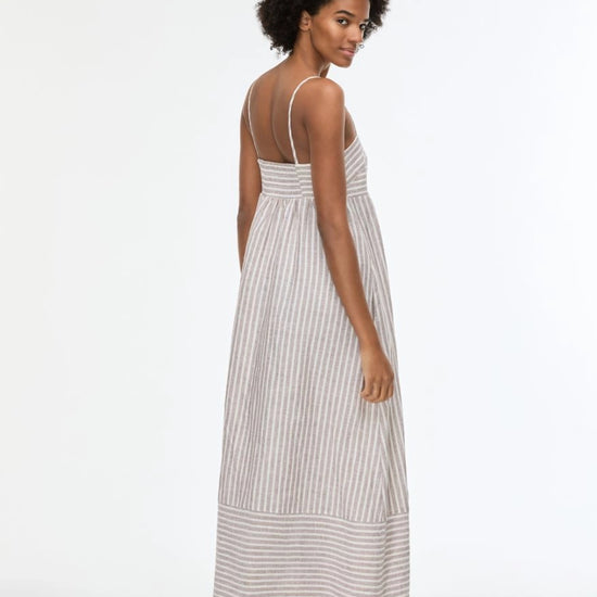 Woman wearing a long striped dress on a white background