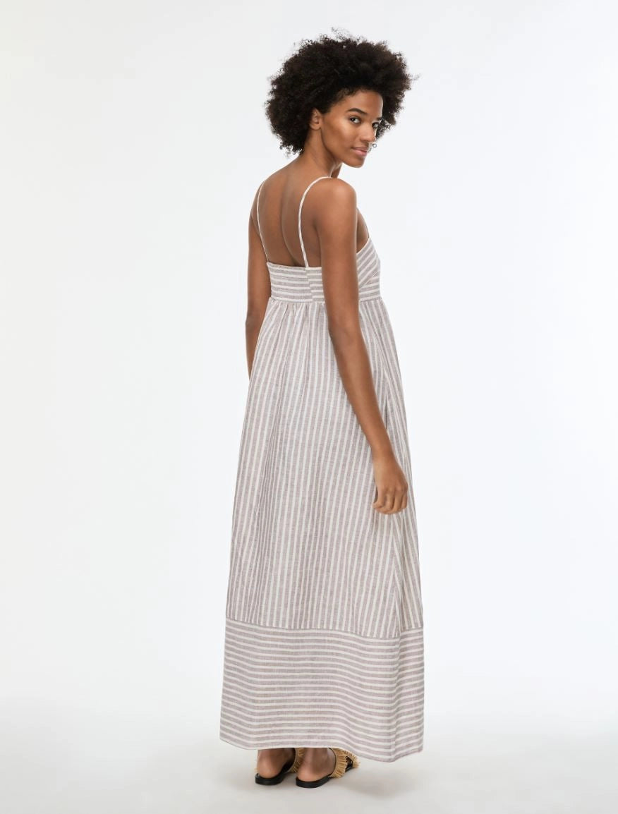 Woman wearing a long striped dress on a white background