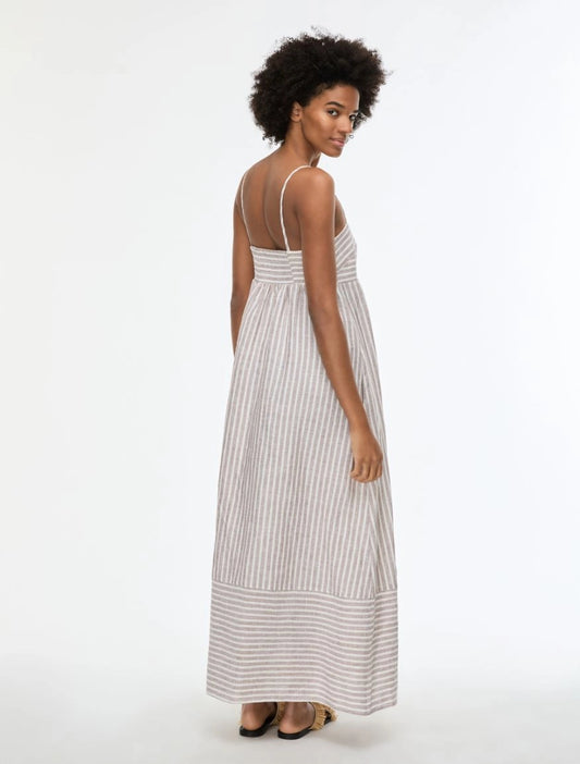 Woman wearing a long striped dress on a white background