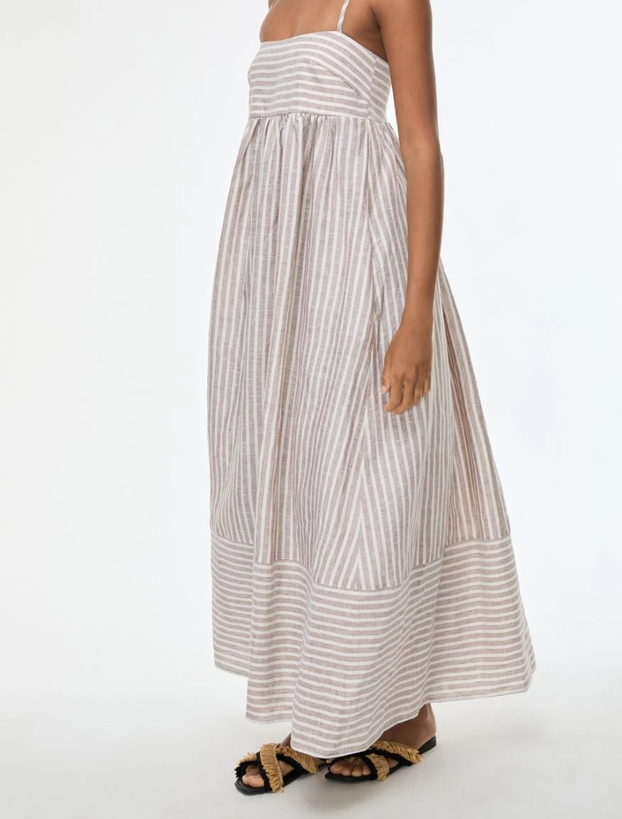 Woman wearing a long striped dress on a white background