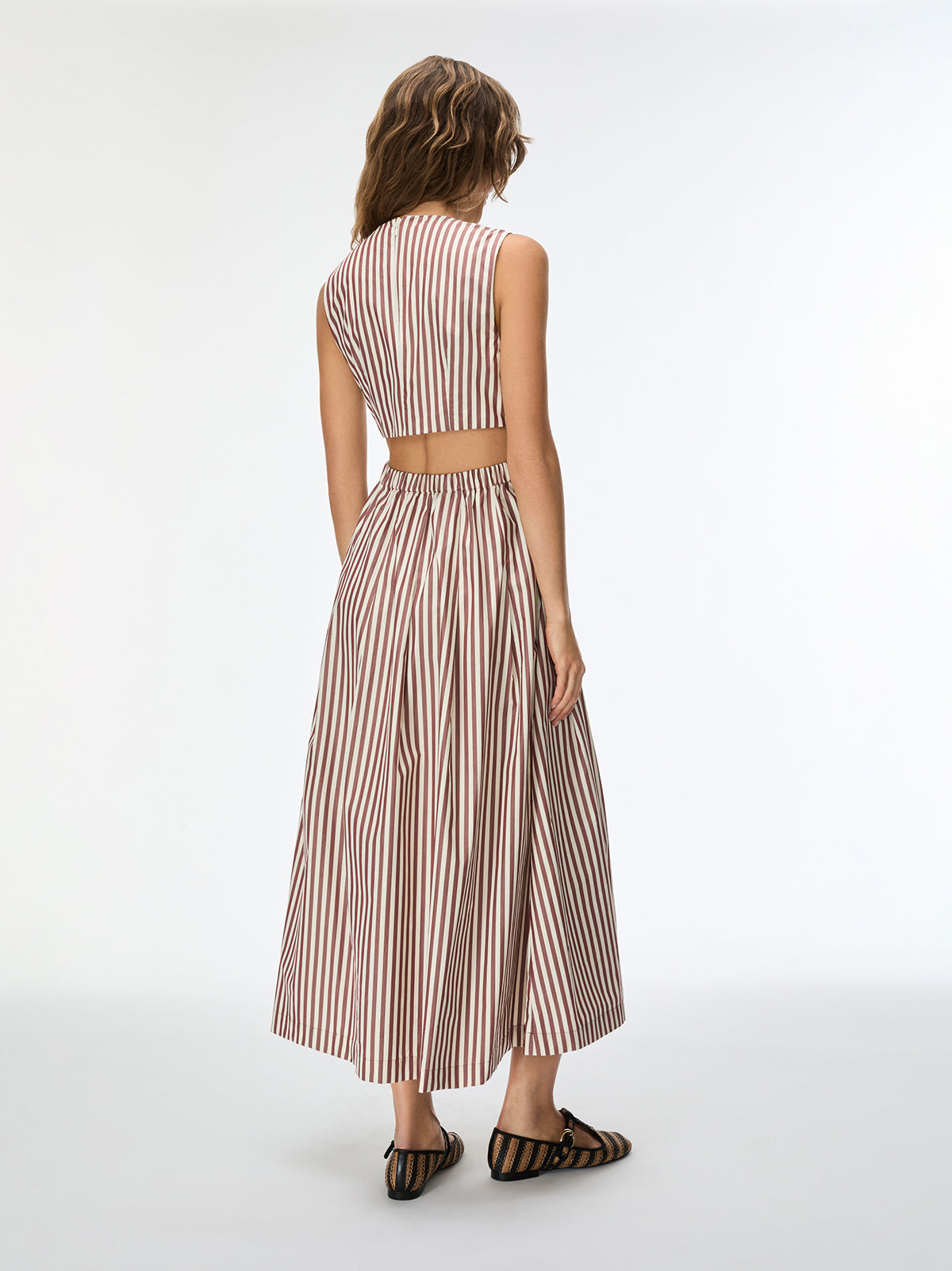 Woman wearing a striped two-piece outfit on a white background