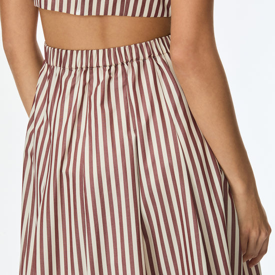 Person wearing a striped dress with a white background