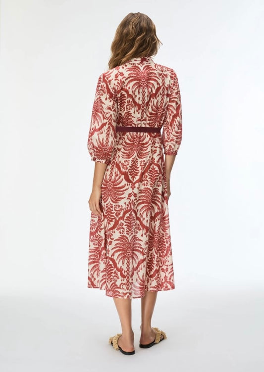 Woman wearing a red and white patterned dress on a white background