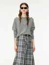 A model wearing a gray knit sweater with shoulder cutouts and a blue-gray plaid skirt, styled with black sunglasses and a headband against a plain white background.