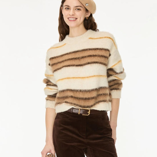 A woman modeling a fuzzy knit sweater with horizontal stripes in cream, brown, and tan, paired with dark brown pants and a beige beret against a plain white background.