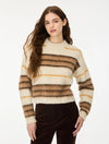 A woman wearing a fuzzy knit sweater with horizontal stripes in cream, brown, and mustard yellow, paired with dark brown pants, against a plain white background.