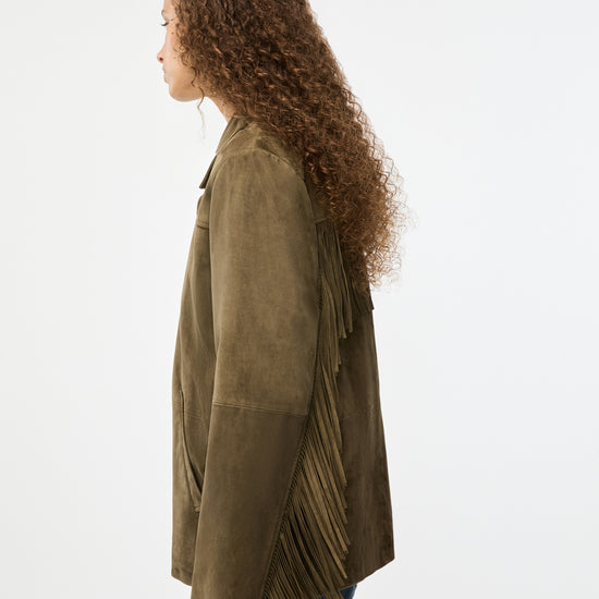 Woman wearing a green jacket with pleated details on a white background
